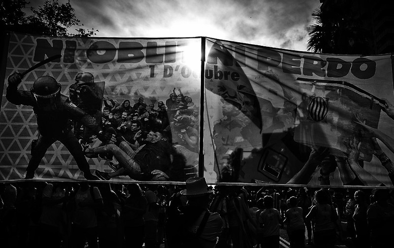 Pancarta en blanc i negre «No oblidem ni perdonem, 1 d’Octubre» amb una il·lustració de càrregues policials