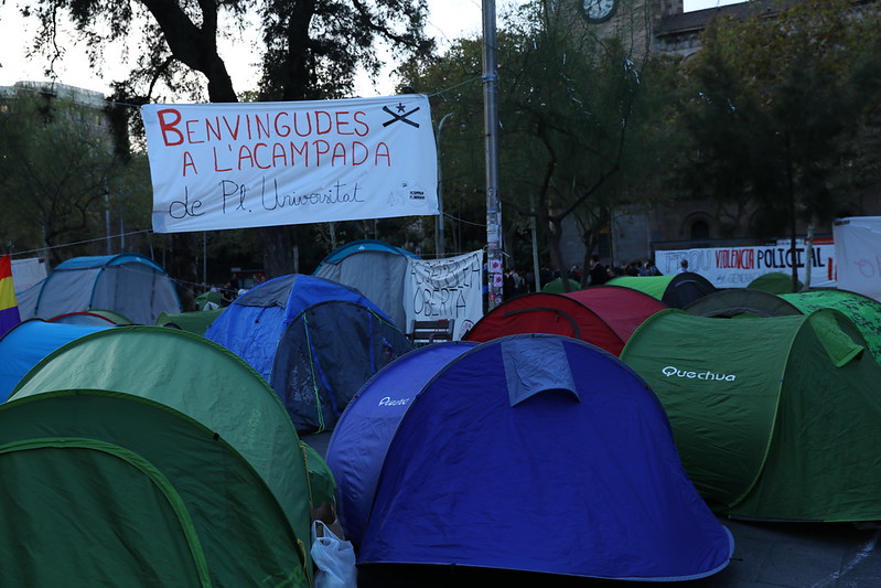 Acampada a la plaça Universitat, amb tendes de campanya i una pancarta «Benvingudes a l’acampada»